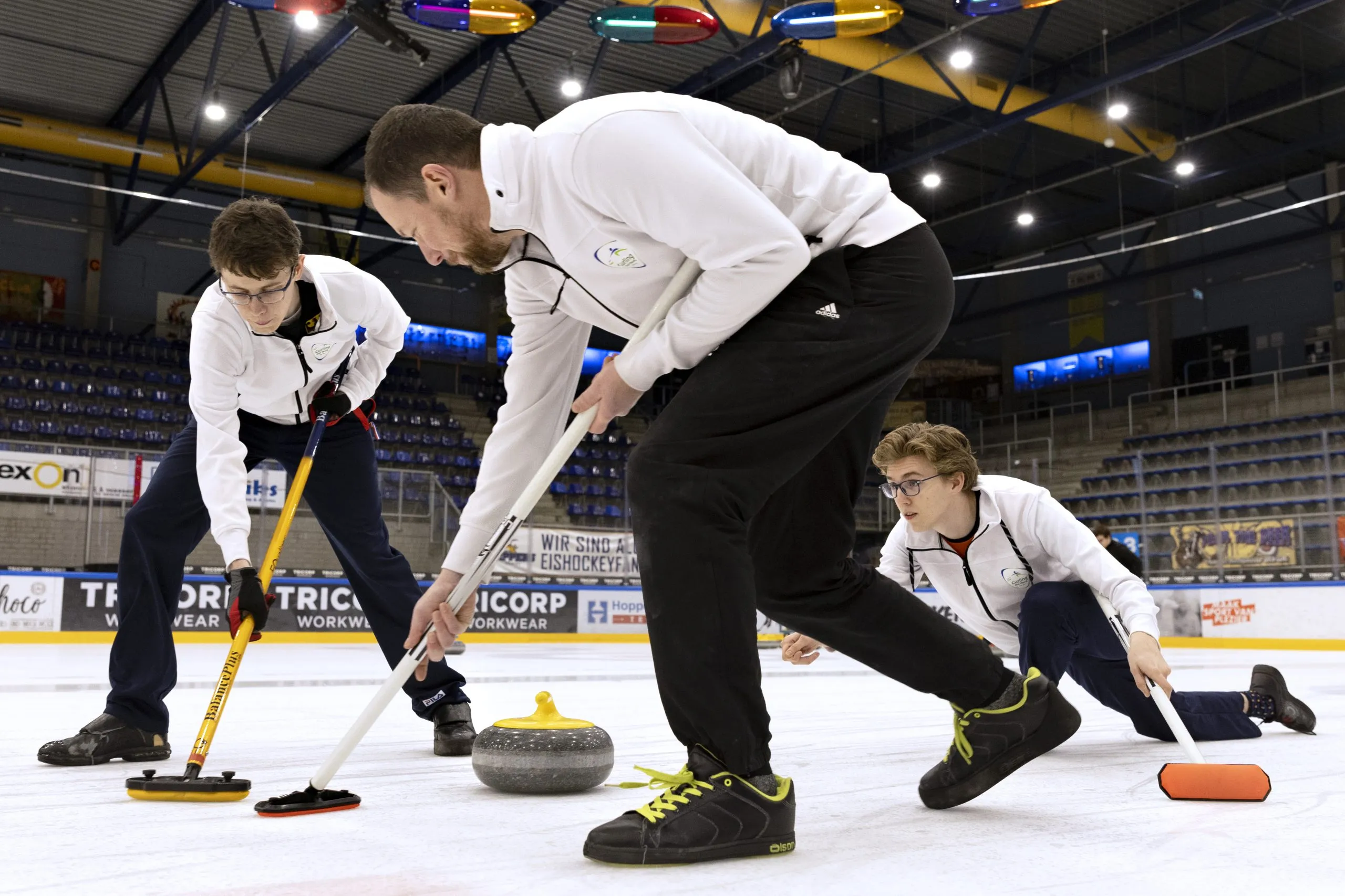 Two players sweeping in front of a curling stone