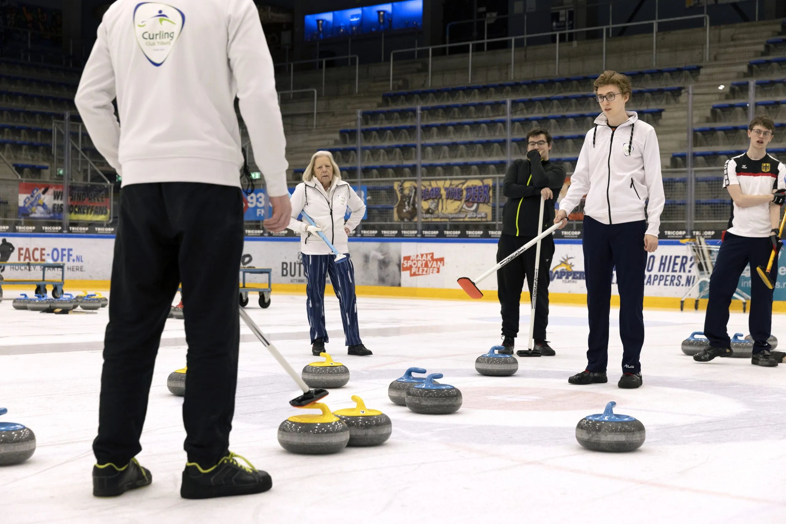 Members on the ice among the curling stones during practice